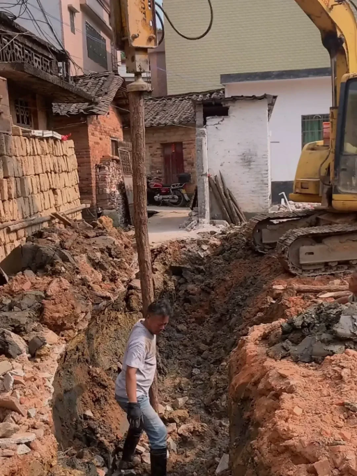 Hydraulic breaker driving wooden posts manually, showing unsafe post handling and low efficiency