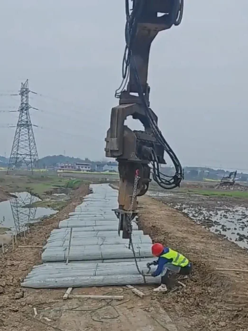 Hydraulic breaker on site with wooden posts, highlighting need for safer and faster post driving solution